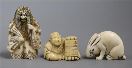 Three Japanese ivory netsuke - Kabuki figure with rotating double face, rabbit and street vendor